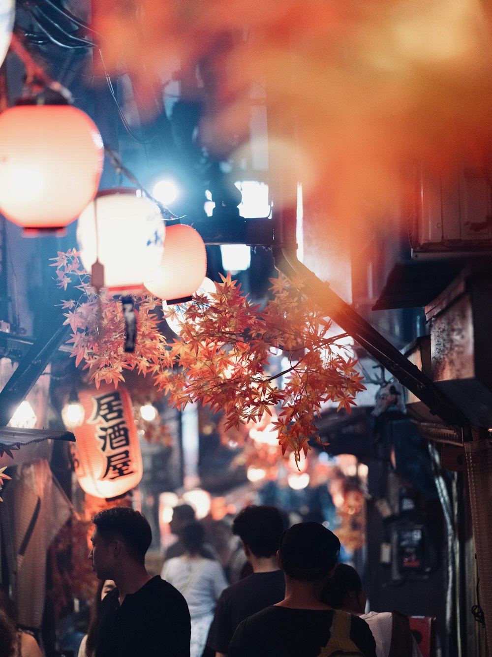 a group of people walking down a street at night