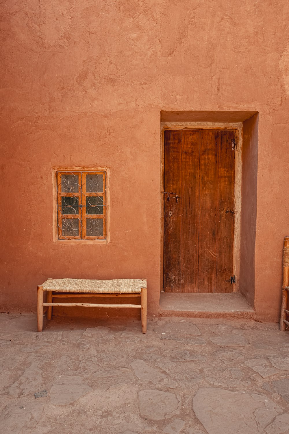 a wooden bench sitting in front of a brown building