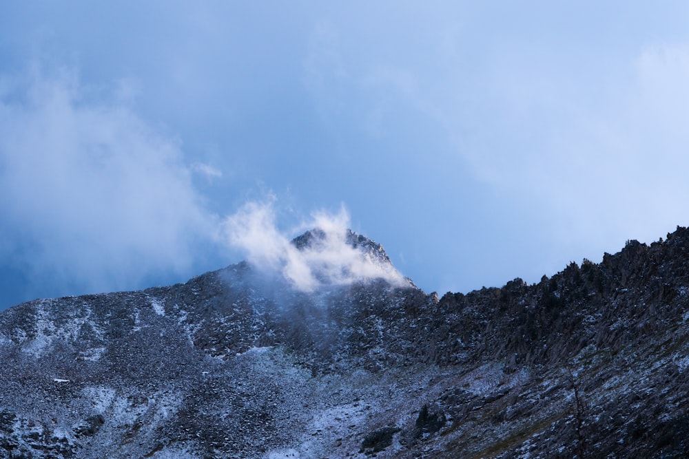 a snow covered mountain with a cloud in the sky