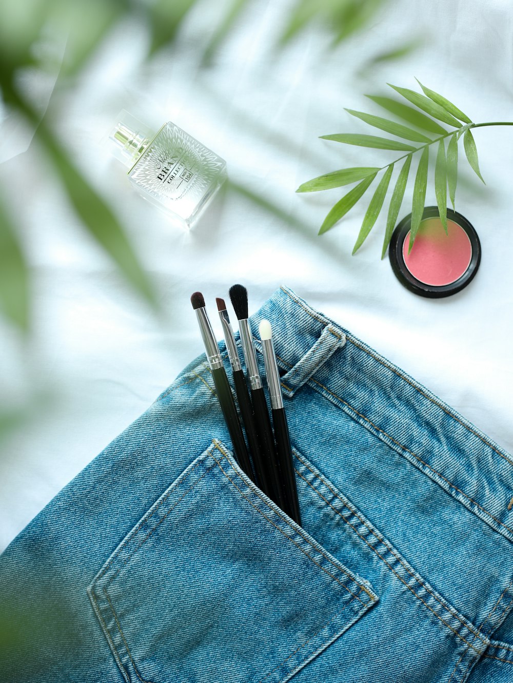 a pair of jeans with makeup brushes in the pocket