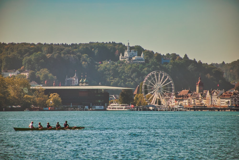 a group of people rowing a boat on a lake