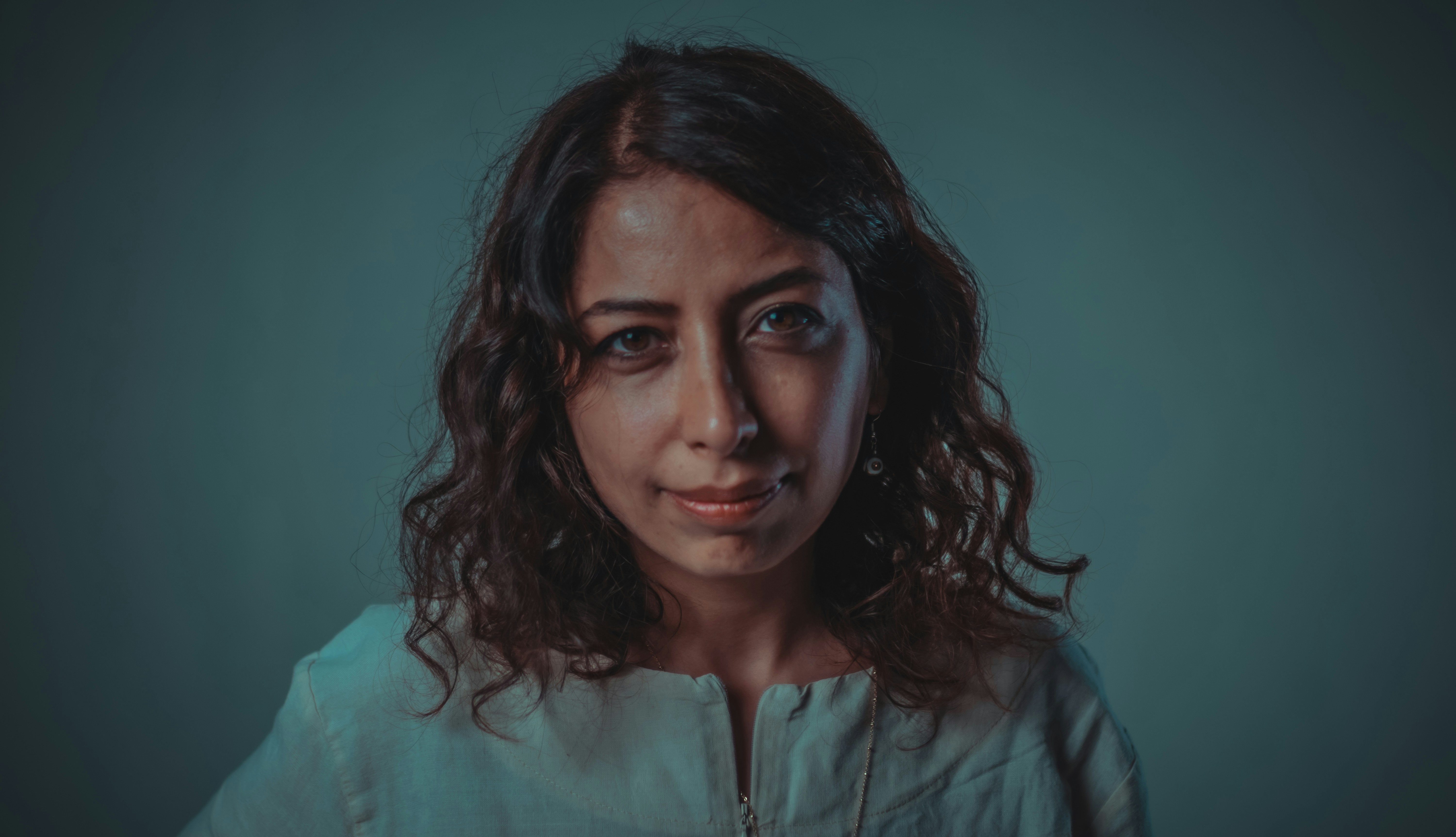 a woman in a white shirt is looking at the camera (Photo by joan m on Unsplash)