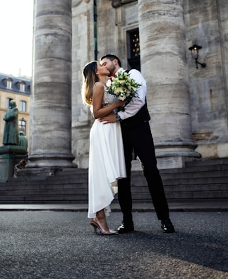A beautiful wedding scene with a couple sharing a kiss.