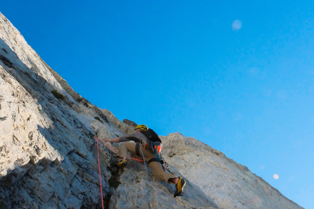 a man climbing up the side of a mountain