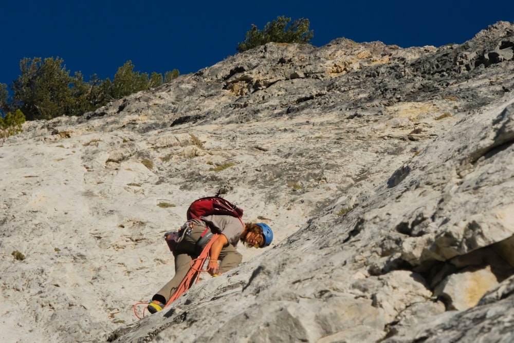 a man climbing up the side of a mountain