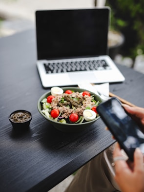 a person taking a picture of a plate of food