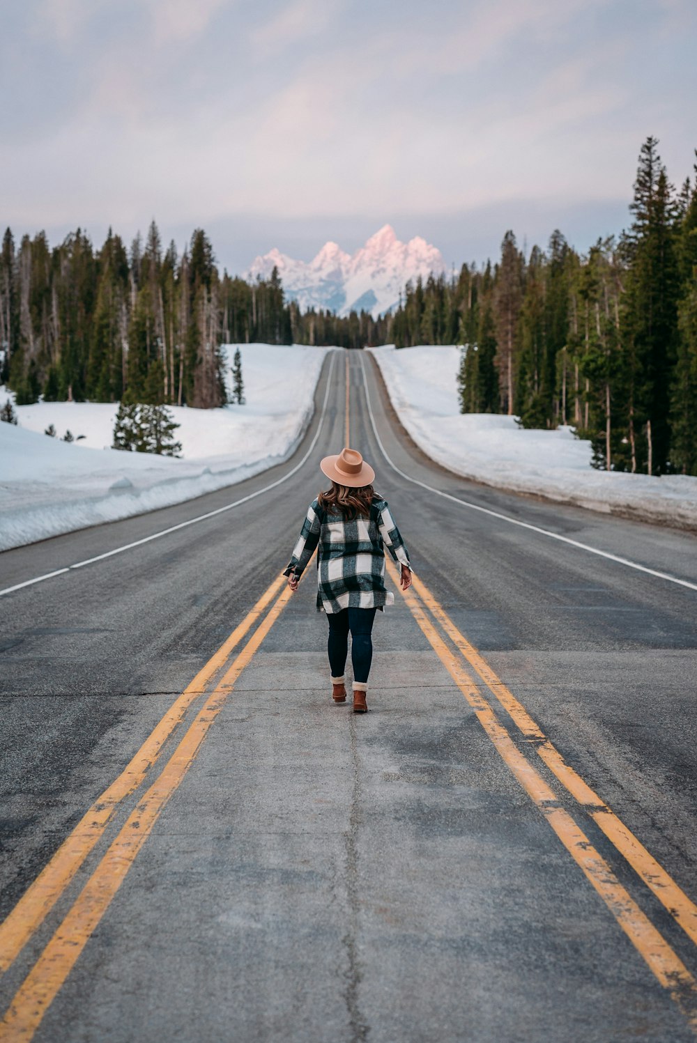 a woman walking down the middle of a road