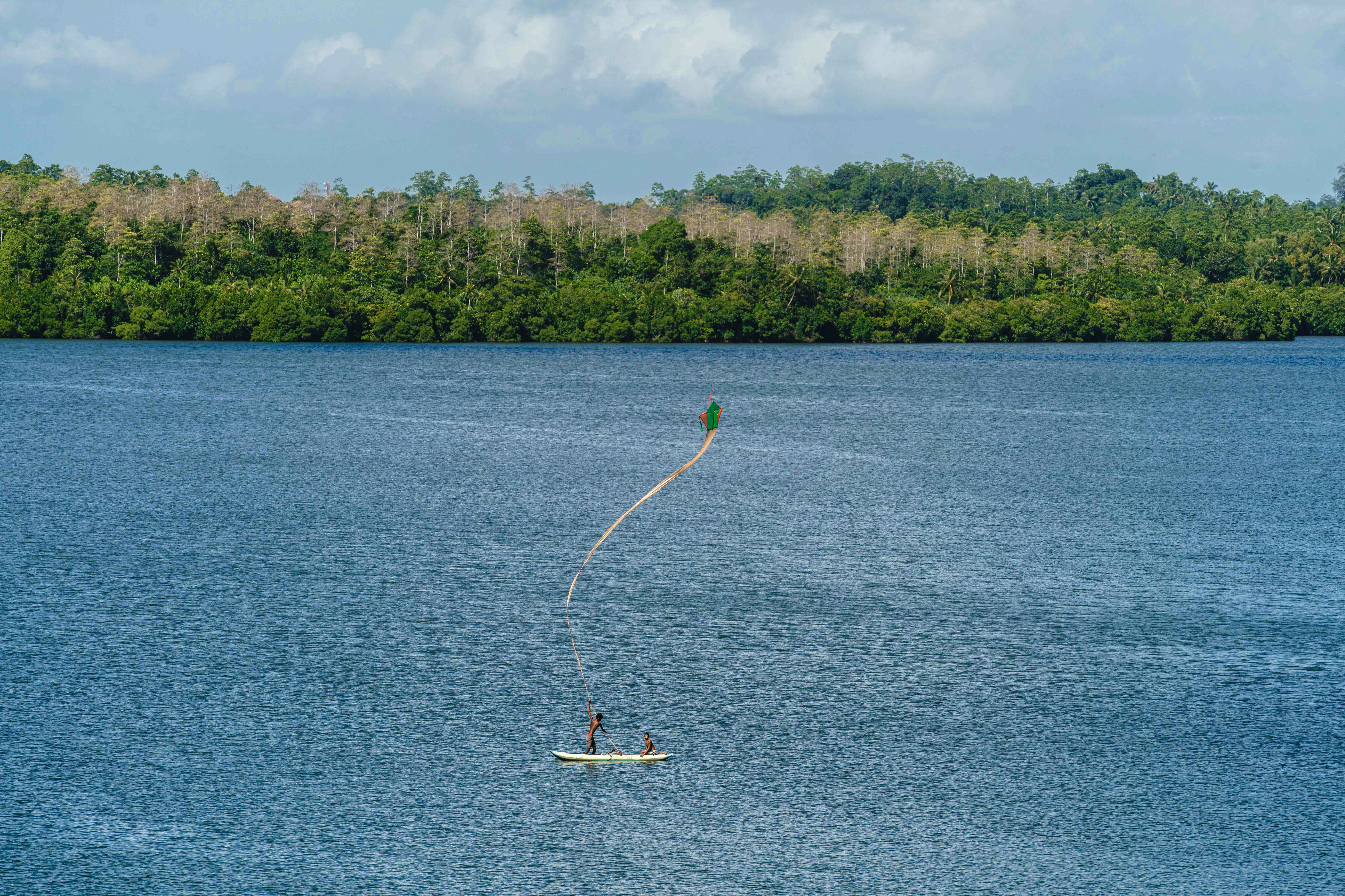 Two boys and their kite on a SUP.