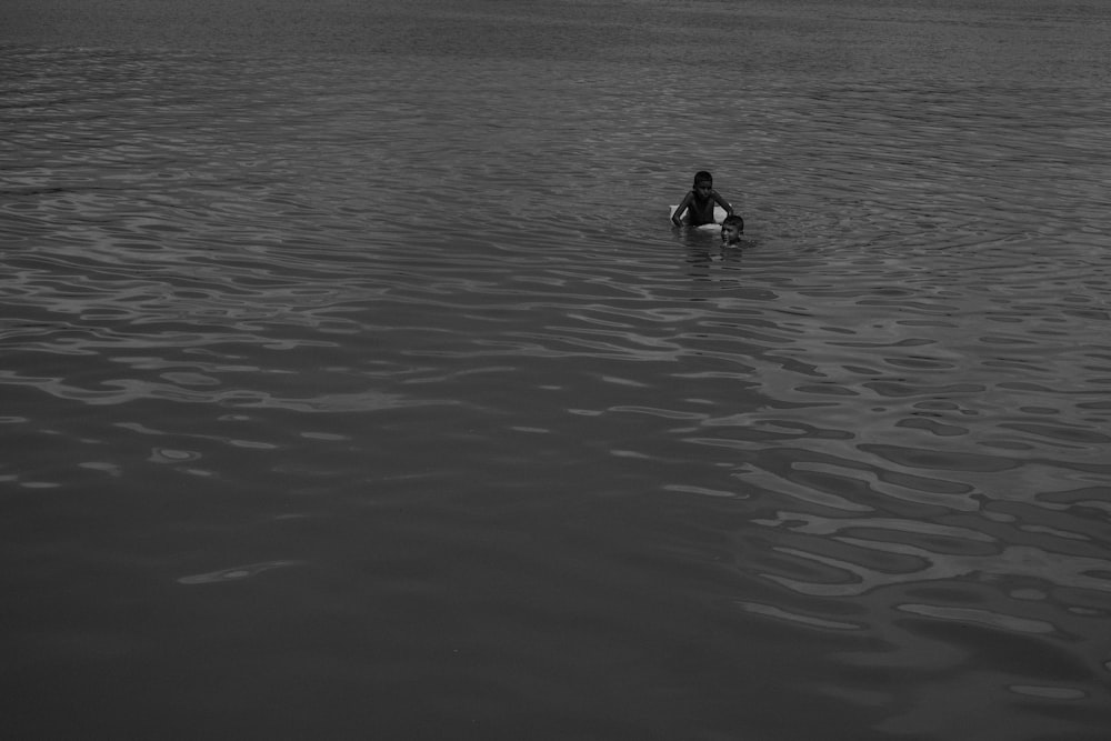 a person sitting on a surfboard in a body of water