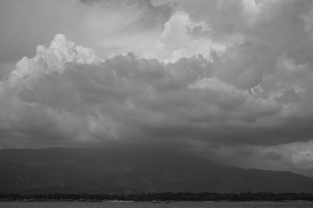 a black and white photo of clouds over a body of water