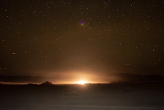 A mysterious glowing UFO hovering silently over a desert landscape at twilight.