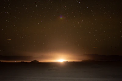 A mysterious glowing UFO hovering silently over a desert landscape at twilight.
