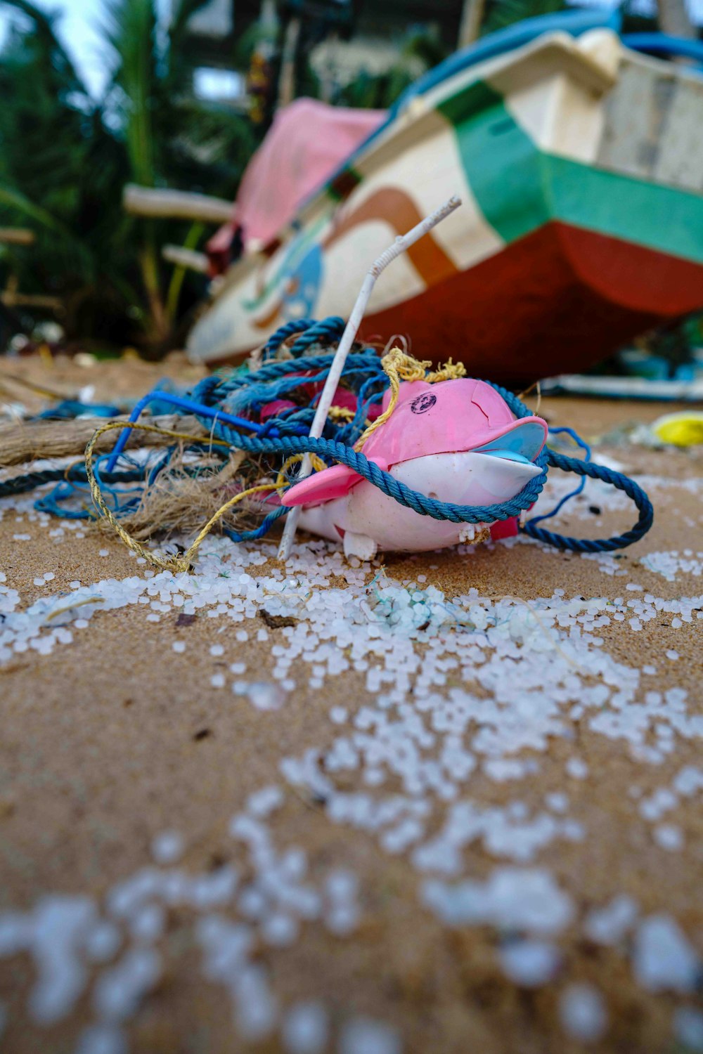 ein rosafarbenes Stofftier sitzt auf einem Sandstrand