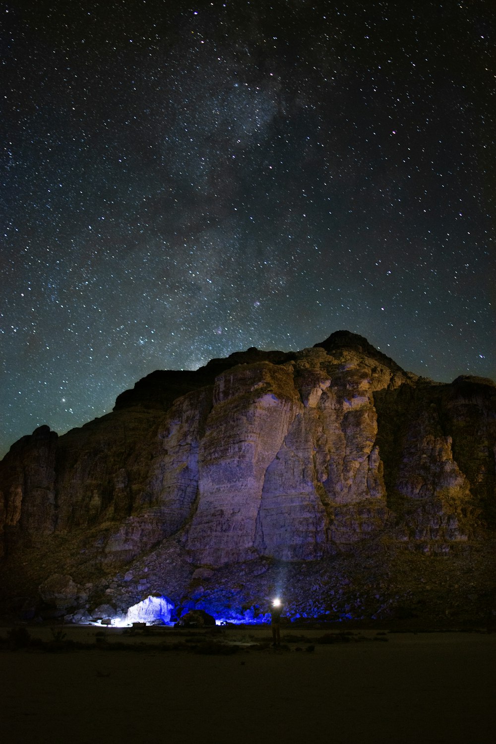 a mountain under a night sky filled with stars