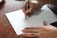 Close-up of a hand sketching a detailed illustration with pencils on textured paper.