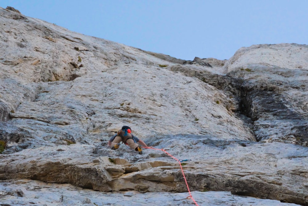 a man climbing up the side of a mountain