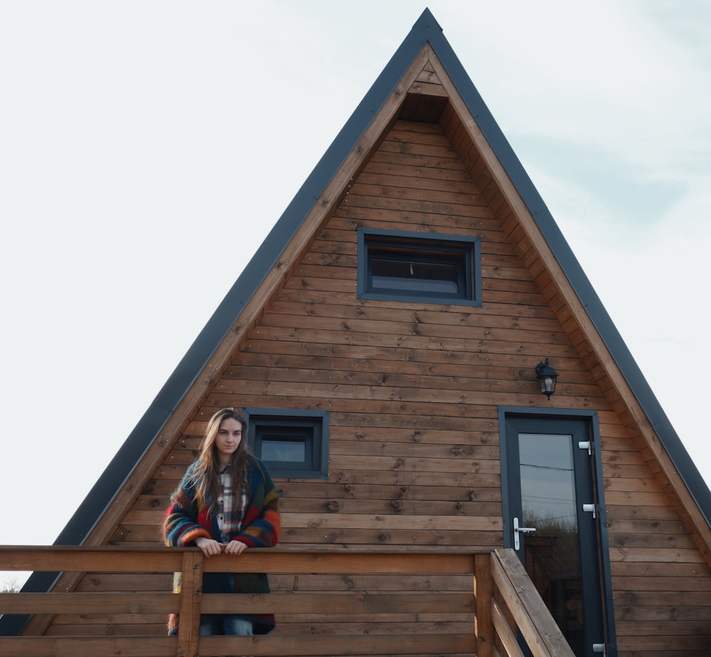 a woman standing on a deck in front of a house