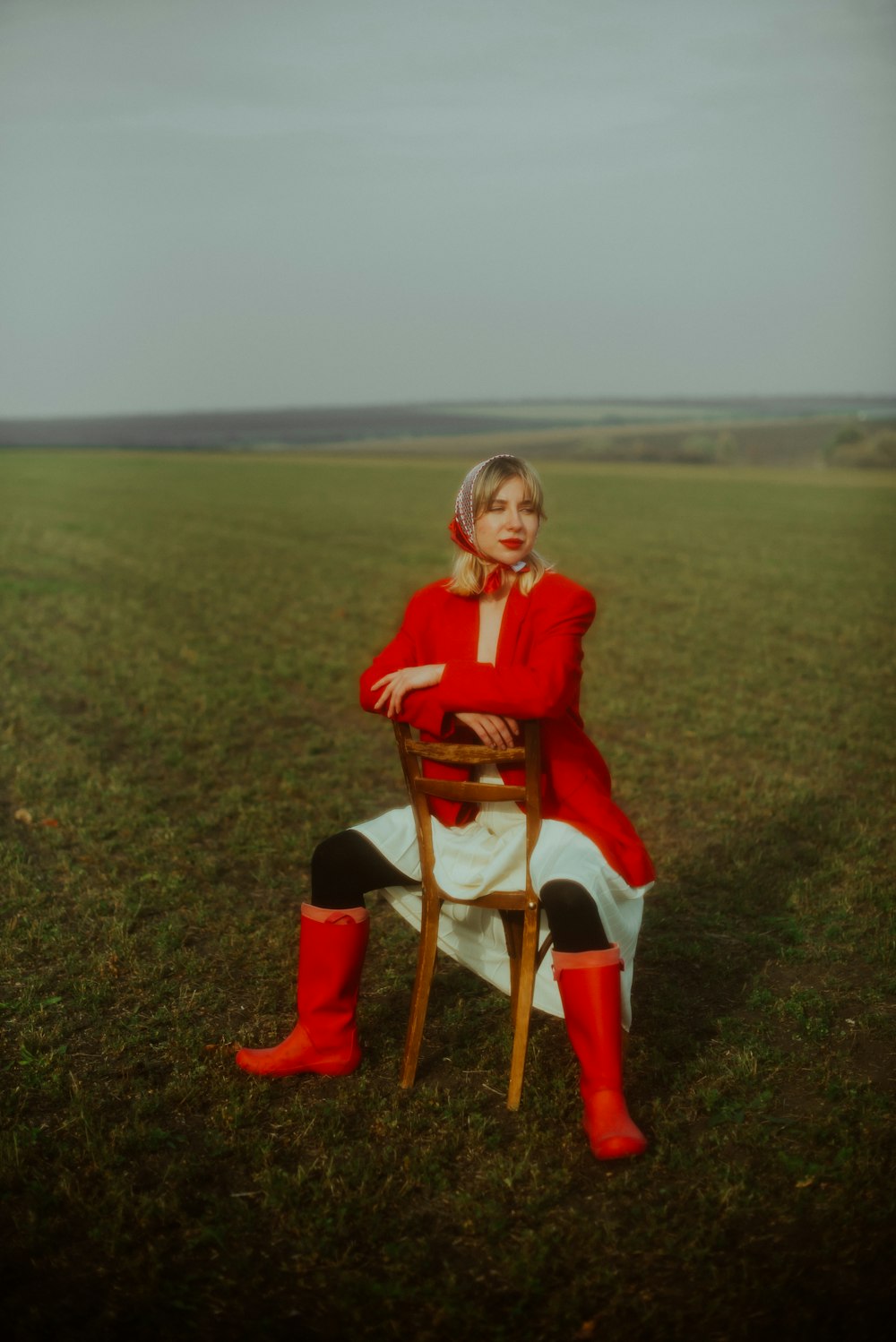 a woman sitting in a chair in a field