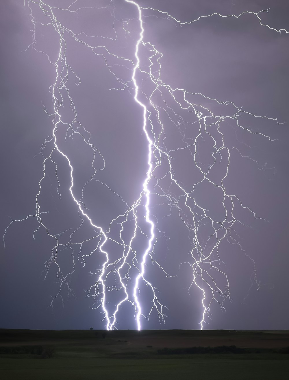 a lightning bolt strikes across a cloudy sky