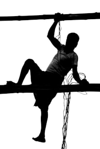 A young athlete practicing advanced calisthenics moves on parallel bars outdoors.