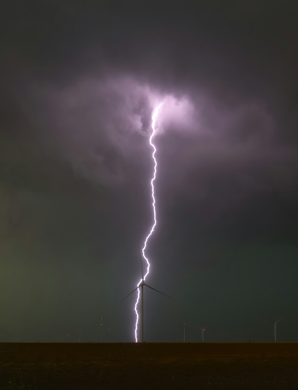 a lightning bolt hitting through a dark cloudy sky