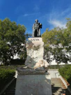 a statue of a man sitting on top of a bench