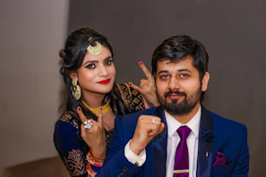 A styled shot of matching headwraps and jewelry paired with coordinating couple’s suite outfits