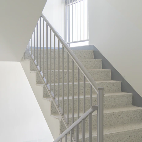 Bright, freshly cleaned staircases with handrails shining under natural light.