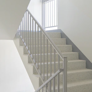 Straight metal staircase with a minimalist design, bright and clean, shown in natural light.