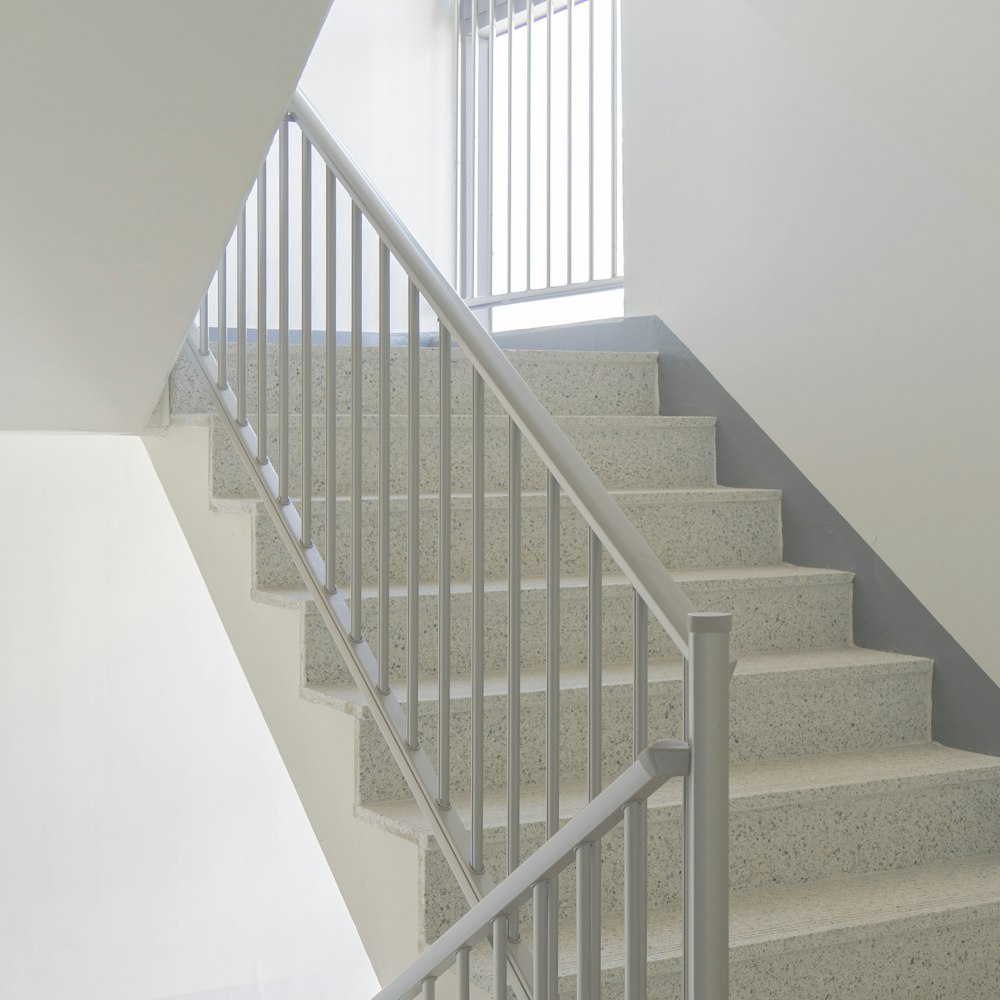 a white staircase with a metal hand rail