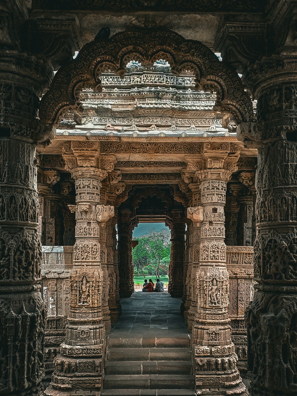 a large stone structure with a couple of people sitting on top of it