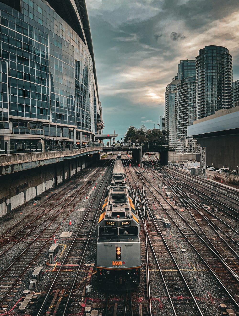 a train traveling through a train station next to tall buildings