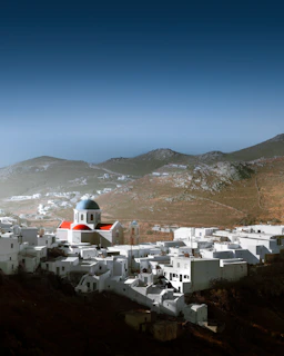 A charming white-washed Santorini village with blue domes under a clear sky