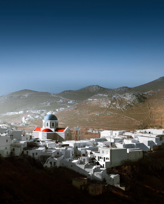A charming white-washed Santorini village with blue domes under a clear sky