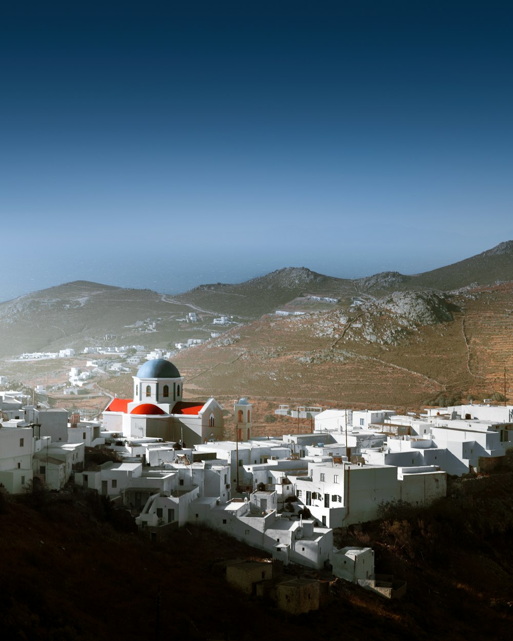 a white building with a red dome on top of a hill