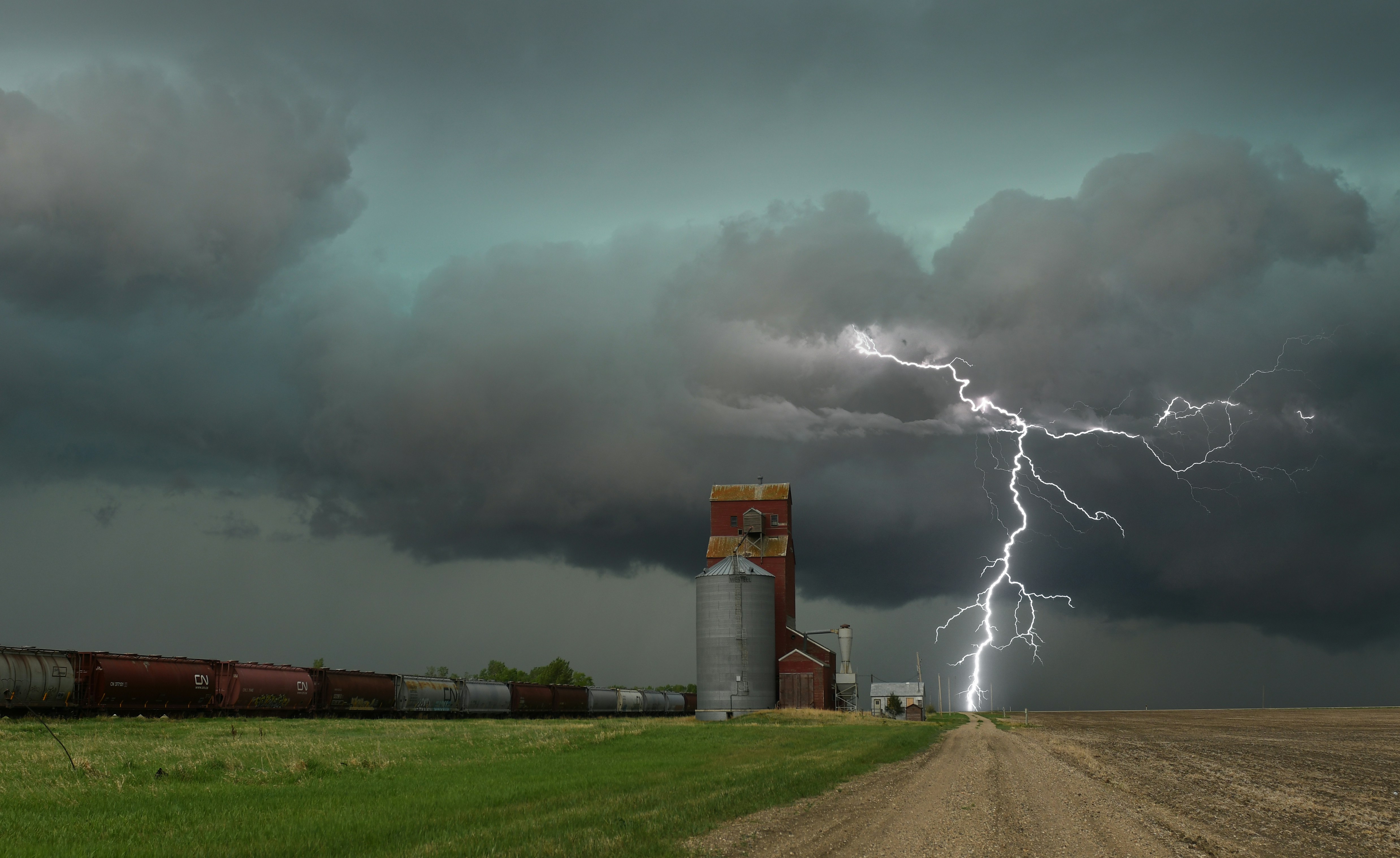 a train on a track with a lightning bolt in the sky