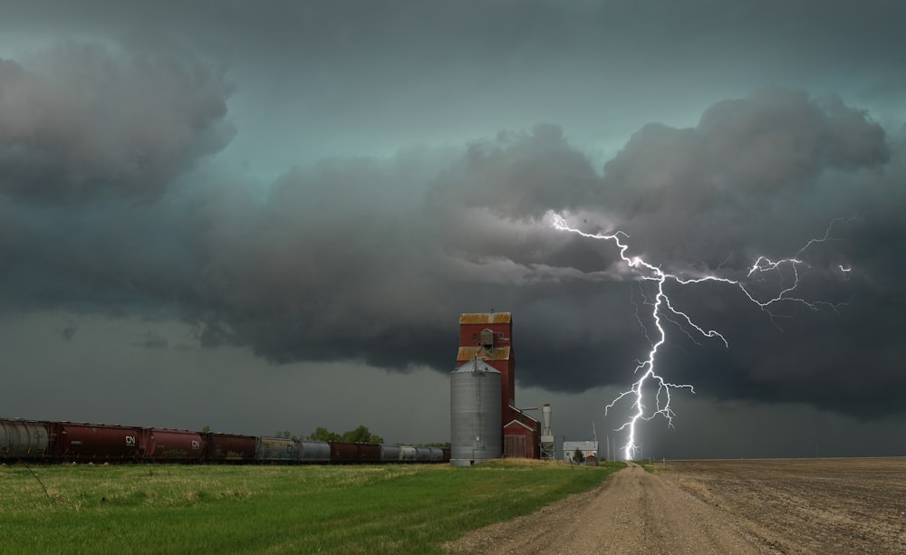 a train on a track with a lightning bolt in the sky