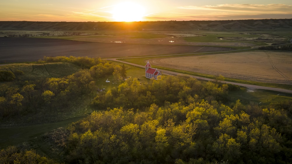 the sun is setting over a rural area