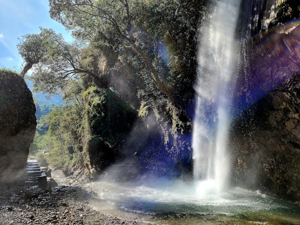 a waterfall with a rainbow painted on the side of it