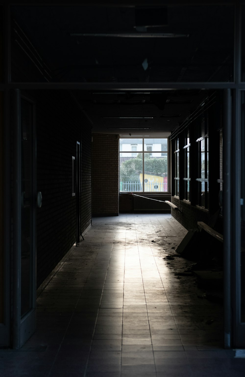 a dark hallway with a bench and a window
