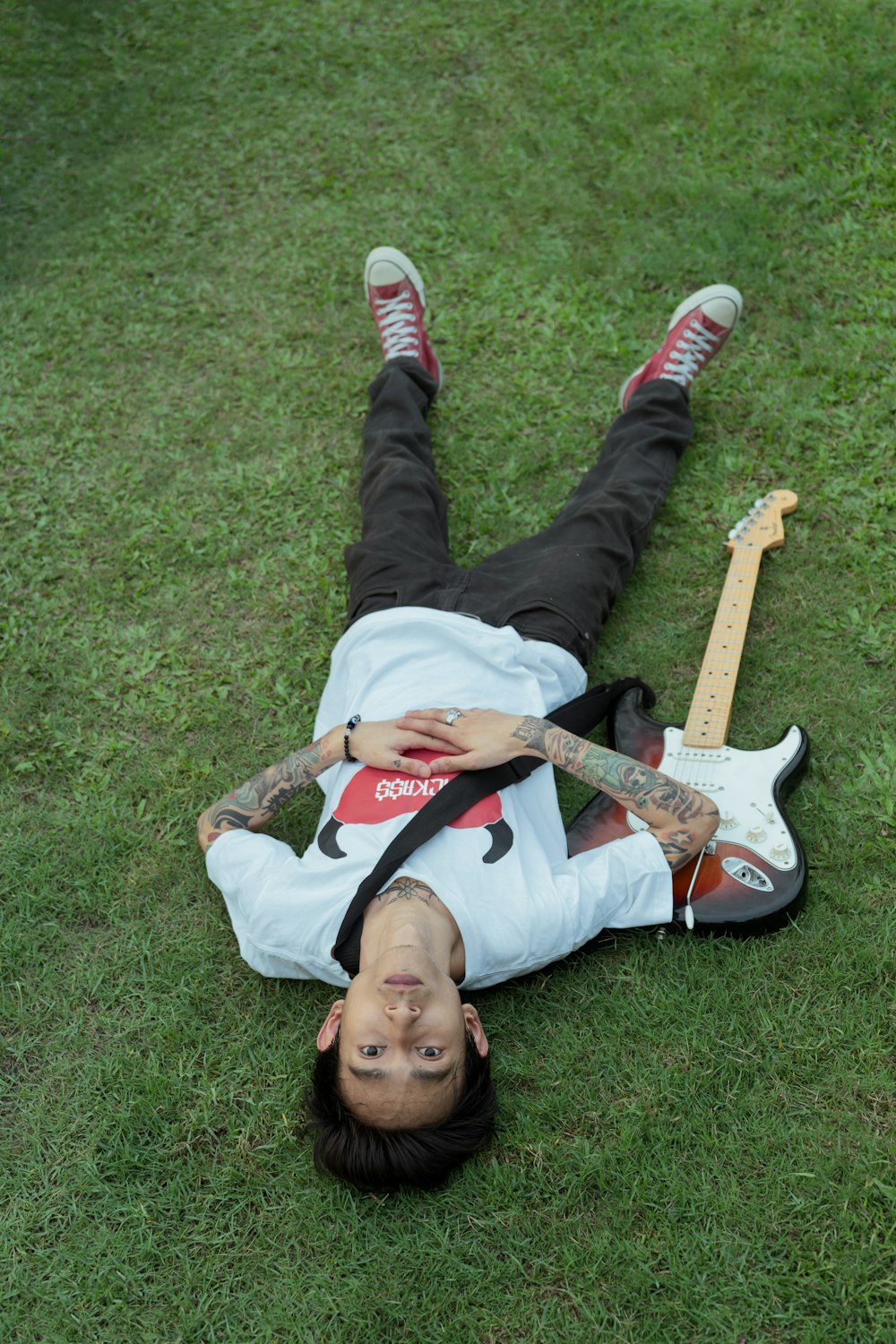 a man laying on the ground with a guitar