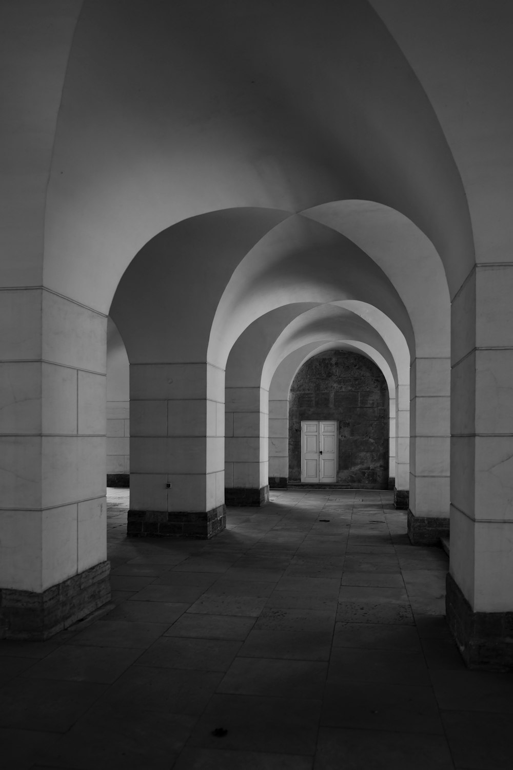 a black and white photo of a long hallway