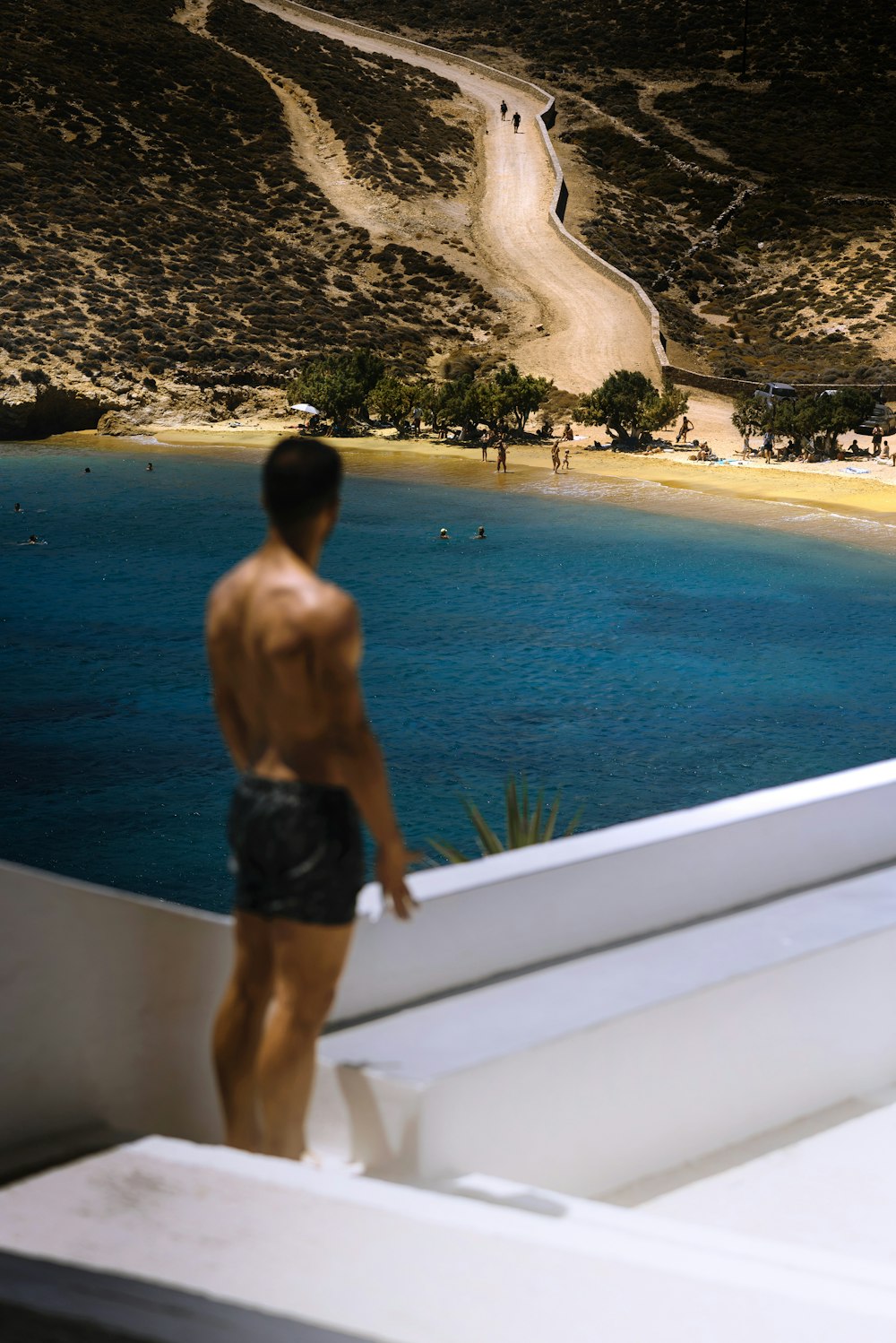 a man standing on a boat looking at a beach