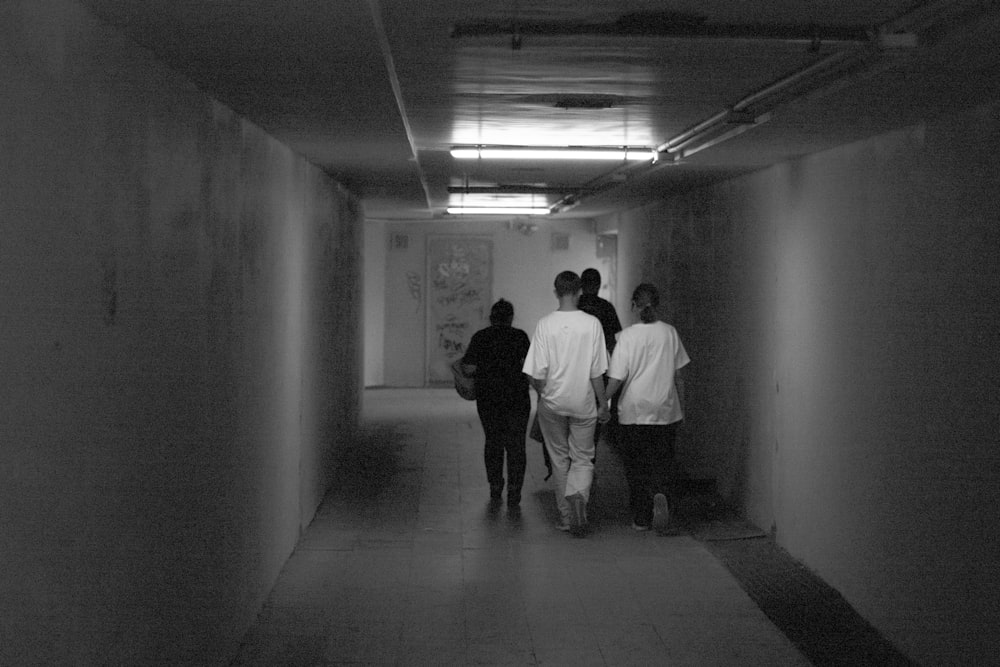 a group of people walking down a long hallway