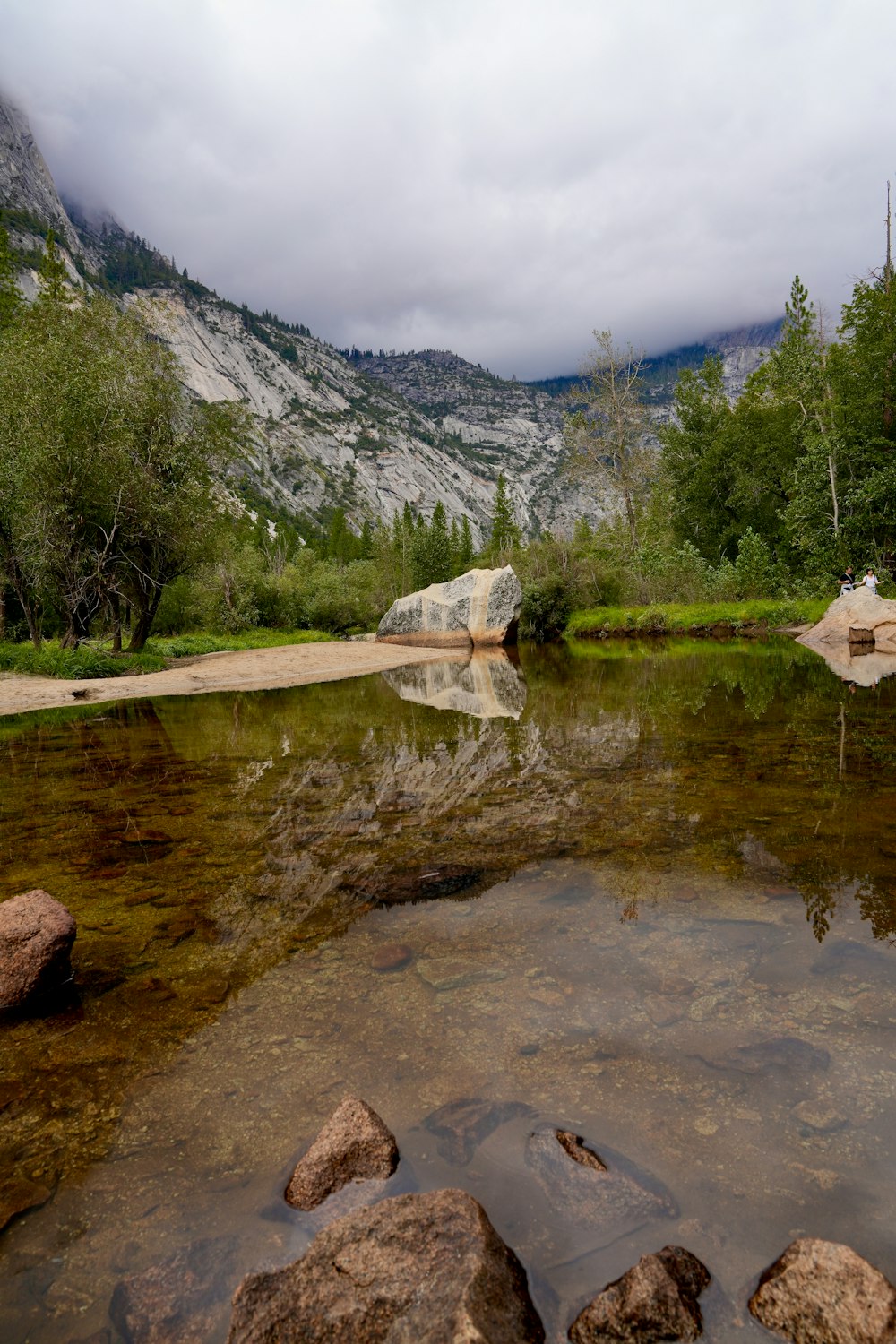 a river with rocks in it and a mountain in the background