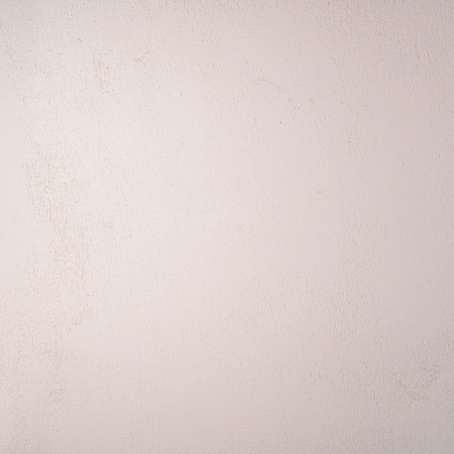 a white wall with a black and white cat sitting on top of it