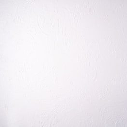 A plain white textured wall with a subtle stucco pattern. The wall shows swirled designs that create a slightly bumpy and irregular surface.