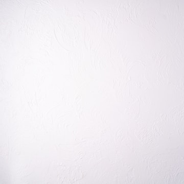 A plain white textured wall with a subtle stucco pattern. The wall shows swirled designs that create a slightly bumpy and irregular surface.