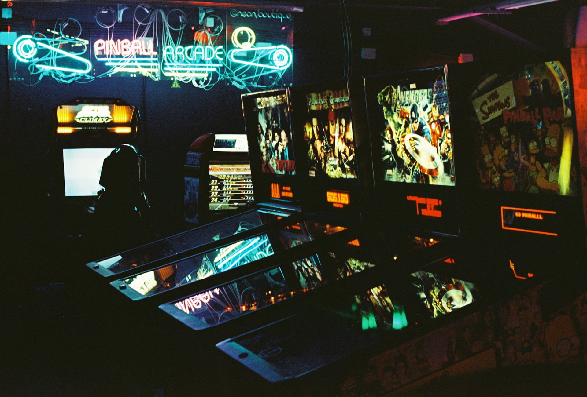 a dark room with neon lights and video game machines