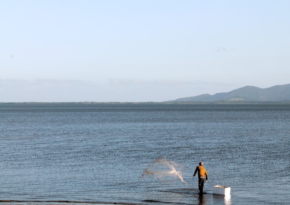 Un hombre parado en el agua con una red de pesca